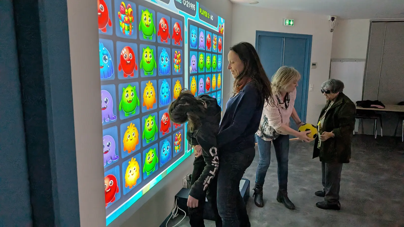 Personne en situation de handicap jouant sur le mur interactif Kmoove