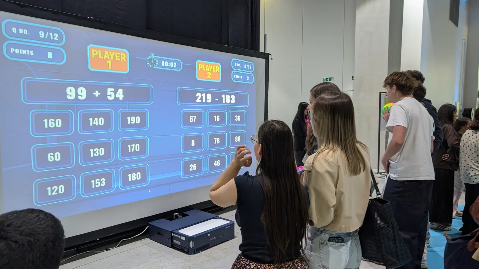 Classe d'élèves en activité sur le mur interactif Kmoove à l'école