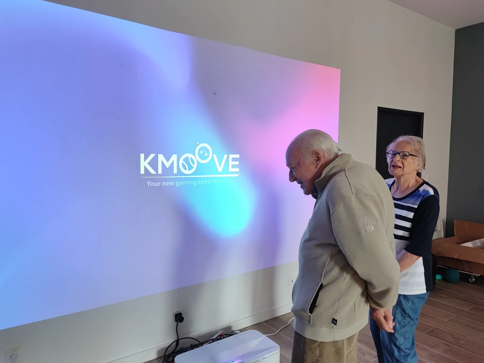 Atelier sensoriel sur mur interactif avec des personnes âgées accompagnées par une animatrice
