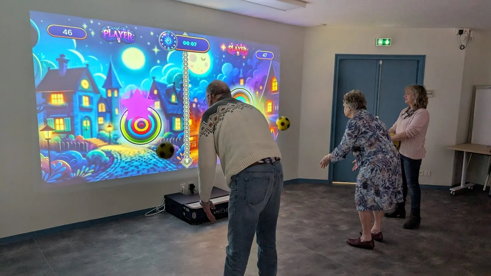 Groupe d'adultes jouant sur un mur interactif Kmoove lors d'une séance collective