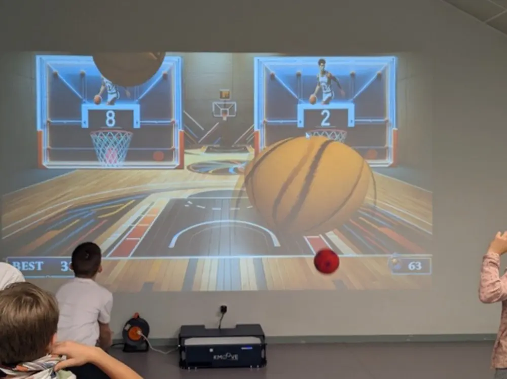 Joueur lançant un ballon sur le mur interactif Kmoove, détection par capteur laser