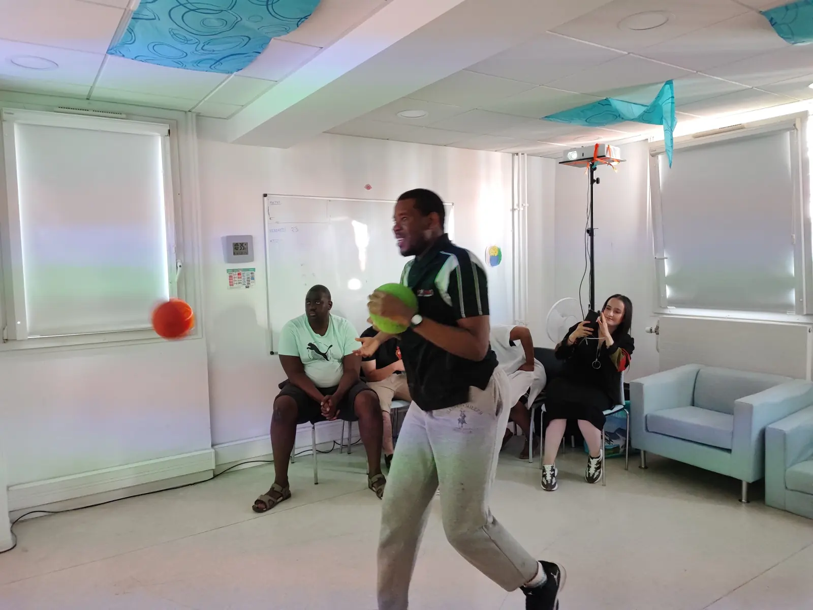Jeune accompagné sur un jeu interactif projeté, en établissement médico-social